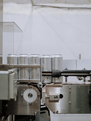Vertical shot of aluminum cans on a conveyor in a factory setting, showcasing industrial processes.
